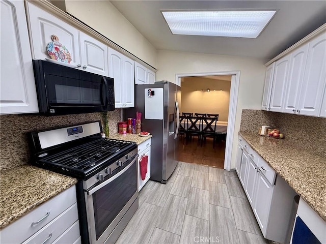 kitchen with white cabinetry, light hardwood / wood-style floors, vaulted ceiling, and appliances with stainless steel finishes