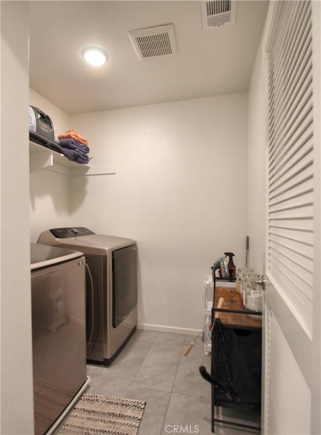 laundry room with light tile patterned flooring and washer and dryer