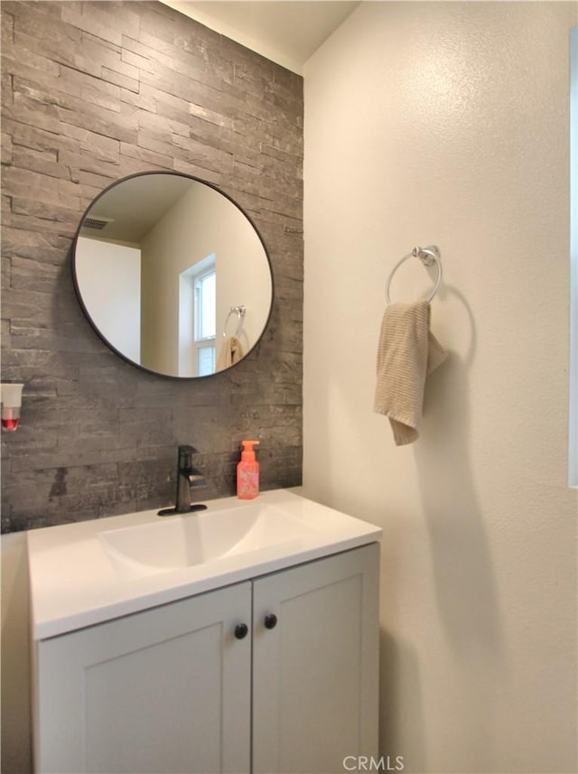 bathroom with vanity and tasteful backsplash