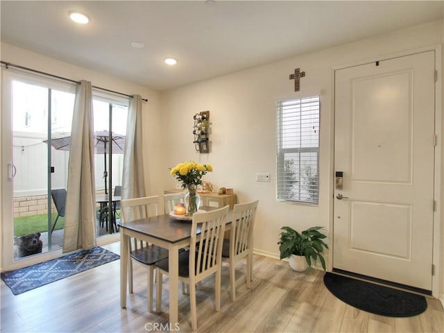 dining space with light hardwood / wood-style floors and a healthy amount of sunlight