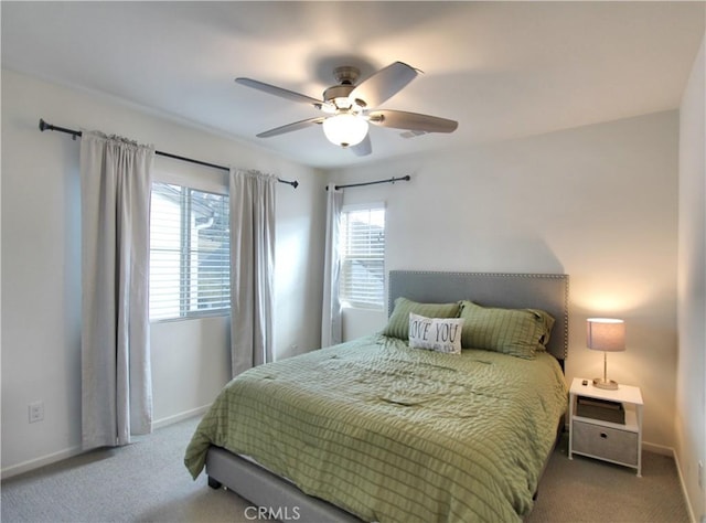 carpeted bedroom featuring multiple windows and ceiling fan