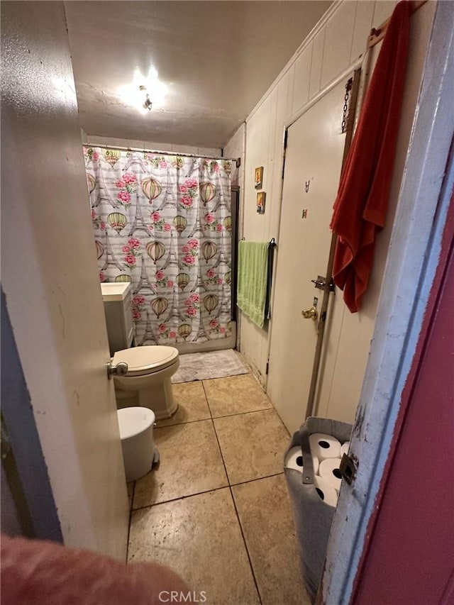 bathroom with tile patterned floors, toilet, and a shower with shower curtain