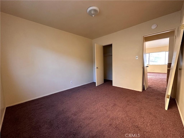 unfurnished bedroom with a closet and dark carpet