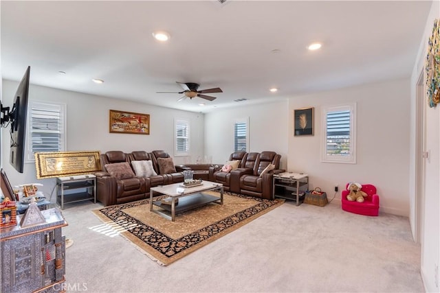 carpeted living room with ceiling fan and a healthy amount of sunlight