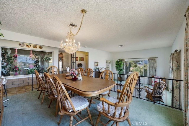 dining area with visible vents, a chandelier, carpet, and a textured ceiling