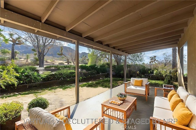 view of patio / terrace featuring an outdoor living space, fence, and a mountain view