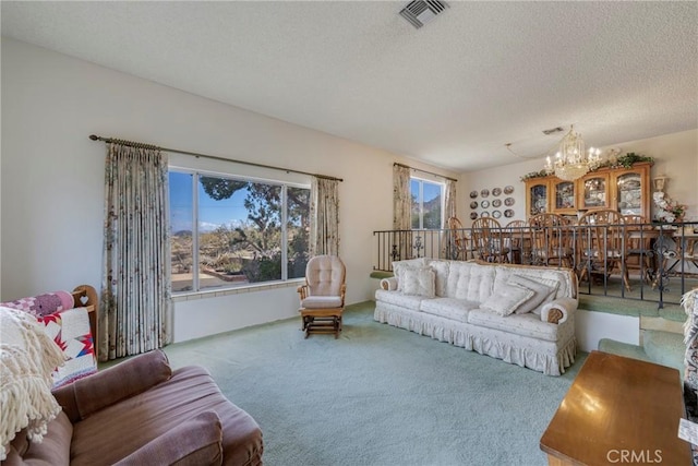 carpeted living area with visible vents, a wealth of natural light, a textured ceiling, and a notable chandelier