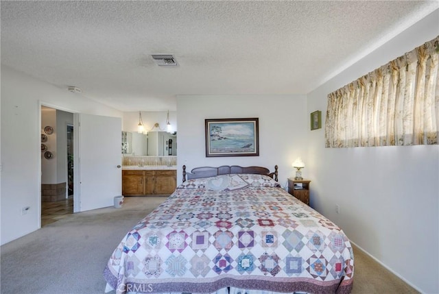 bedroom with light colored carpet, visible vents, and a textured ceiling