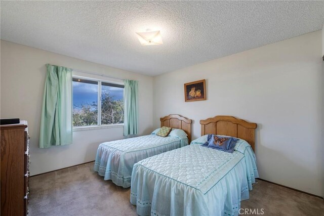 carpeted bedroom featuring a textured ceiling