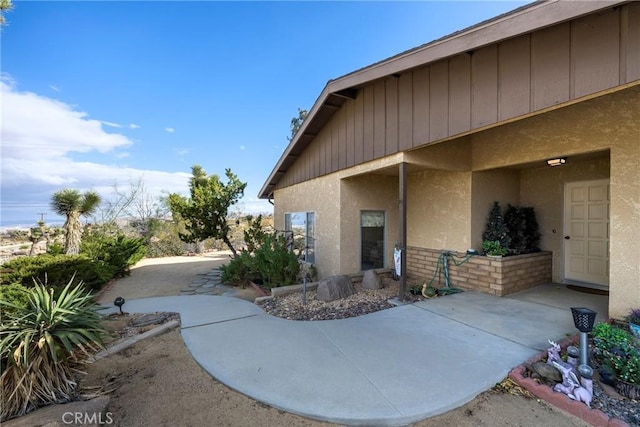 exterior space with stucco siding and a patio