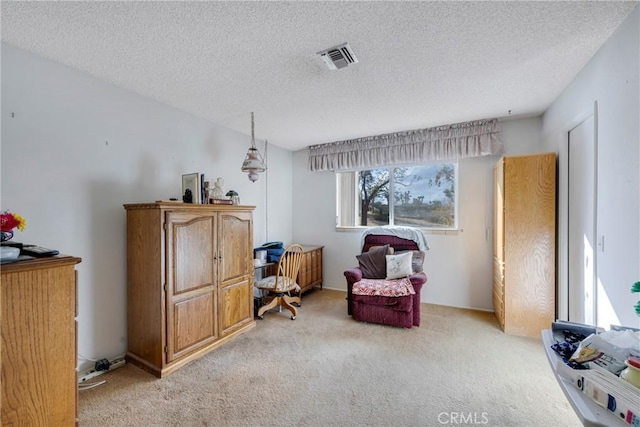 living area featuring light colored carpet, visible vents, and a textured ceiling