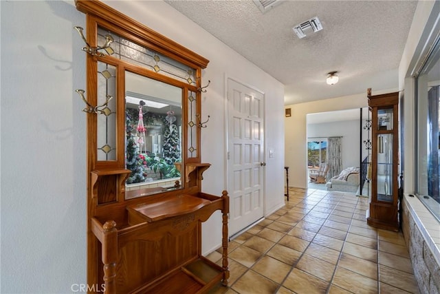 entryway featuring visible vents, a textured ceiling, and light tile patterned floors