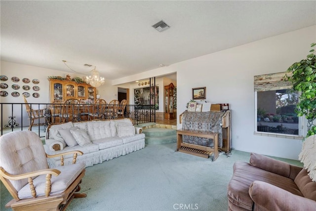 living room with visible vents, a notable chandelier, and carpet floors