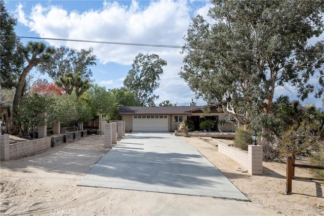 view of front of property with fence, an attached garage, and driveway