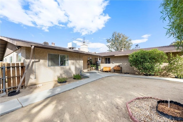 back of house featuring fence, stucco siding, and a patio