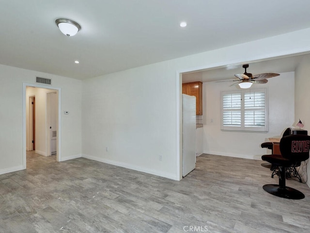 unfurnished room with ceiling fan and light wood-type flooring