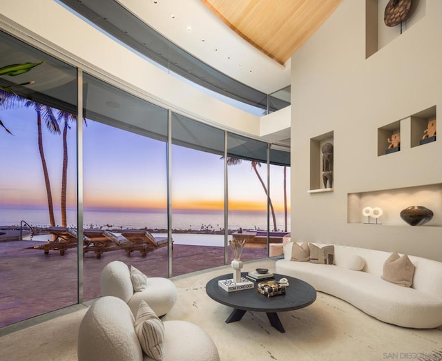 living room featuring a high ceiling and a water view