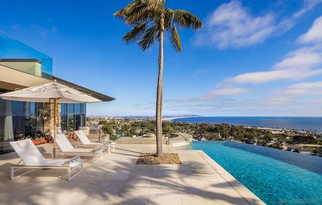 view of swimming pool with a water view and a patio