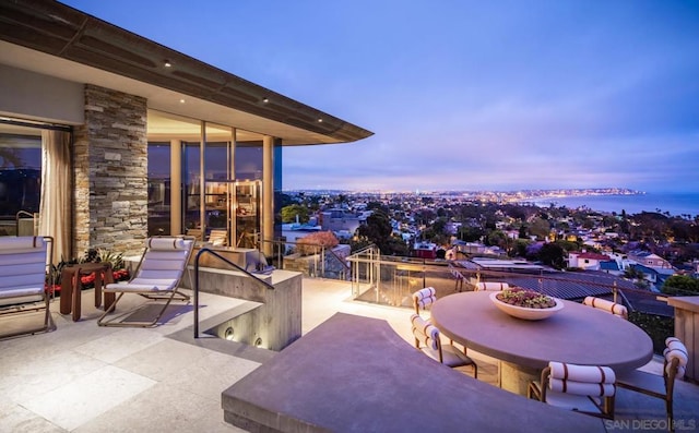 patio terrace at dusk featuring area for grilling