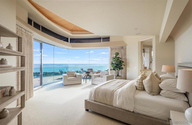 bedroom featuring a water view, carpet, and access to outside