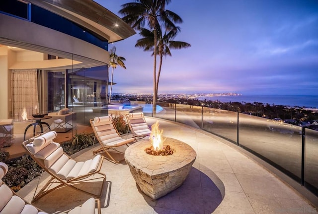 patio terrace at dusk featuring an outdoor fire pit