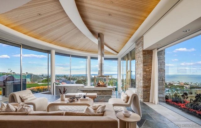 sunroom / solarium with a wealth of natural light, wooden ceiling, and a water view