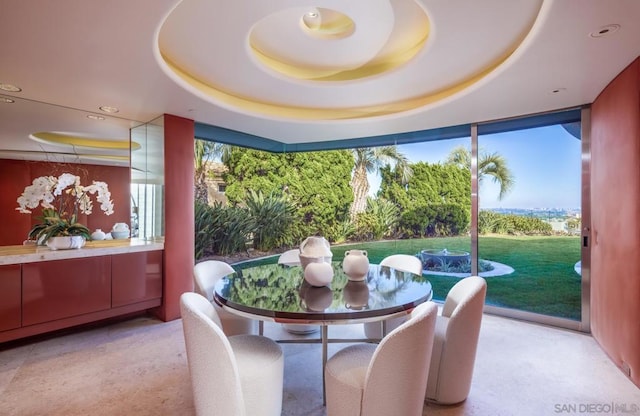 dining space with a tray ceiling and a wealth of natural light