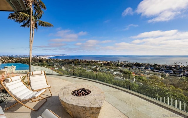 view of patio with a water view and an outdoor fire pit