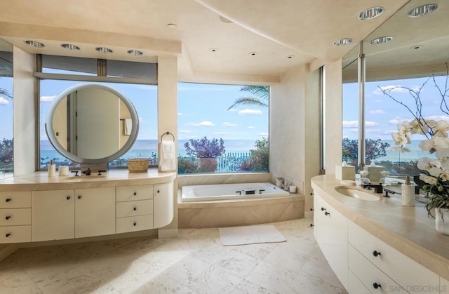 bathroom featuring vanity and tiled bath