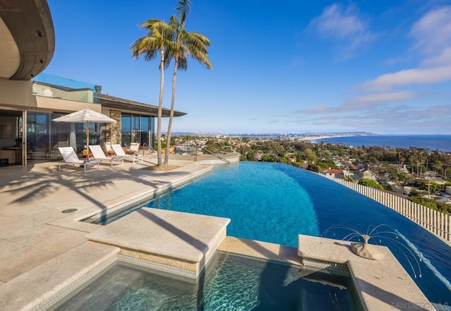 view of swimming pool featuring a water view and a patio area