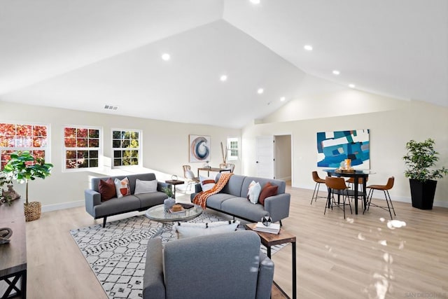 living room featuring light wood-type flooring and high vaulted ceiling