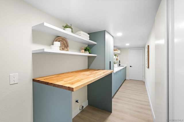 kitchen with light hardwood / wood-style floors, wood counters, and sink