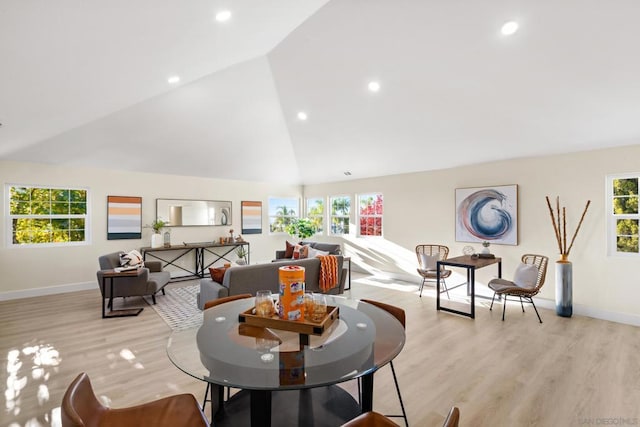 living room featuring lofted ceiling, a healthy amount of sunlight, and light hardwood / wood-style flooring