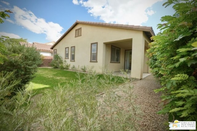 back of house featuring a yard and a patio