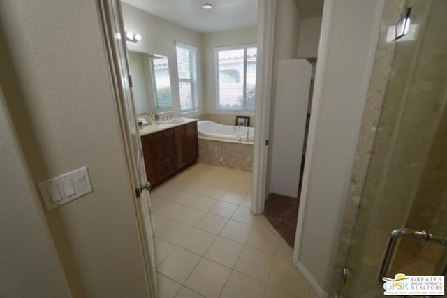 bathroom featuring shower with separate bathtub, vanity, and tile patterned floors