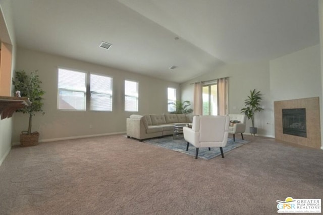 unfurnished living room with a tiled fireplace, light carpet, and lofted ceiling