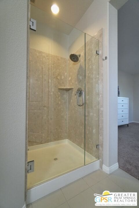 bathroom featuring tile patterned floors and a shower with shower door