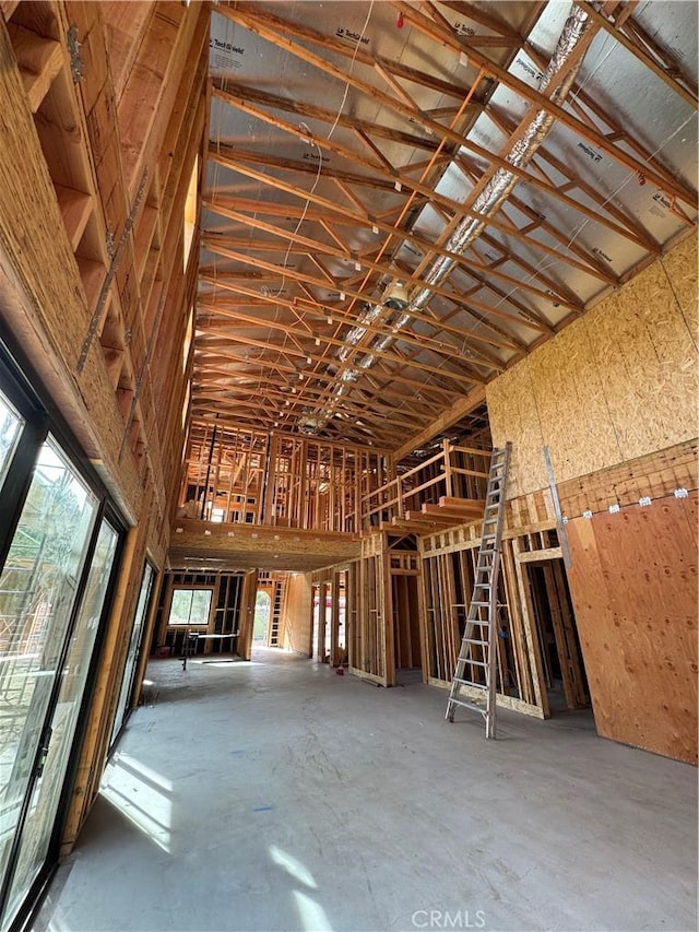 misc room featuring concrete floors and high vaulted ceiling