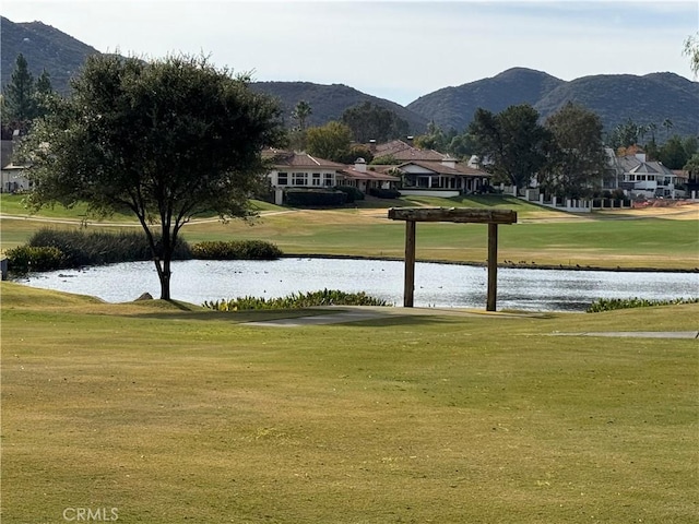 surrounding community with a water and mountain view and a yard