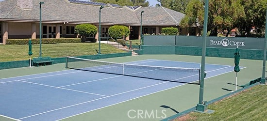 view of sport court featuring a lawn and basketball hoop