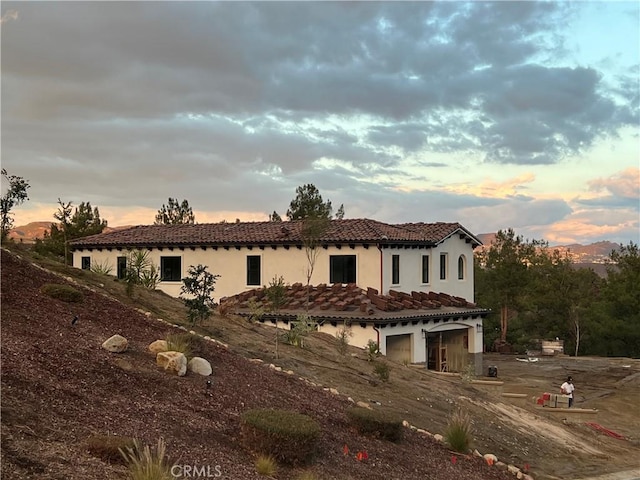 mediterranean / spanish-style house with stucco siding and a tiled roof