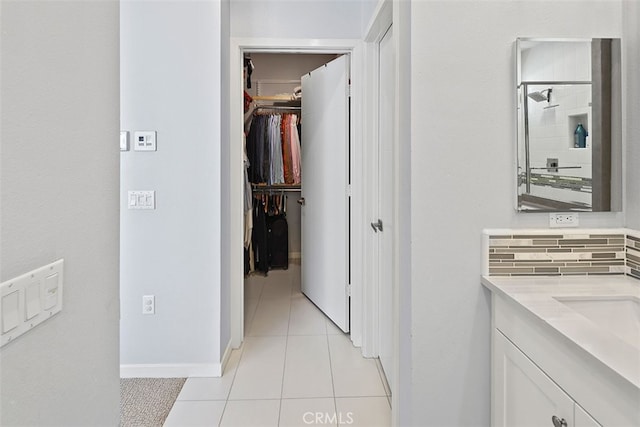 bathroom featuring tasteful backsplash, walk in shower, vanity, and tile patterned floors