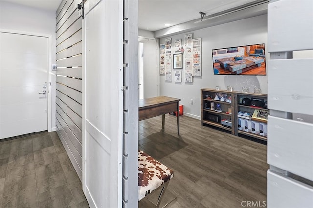 hallway with a barn door and dark hardwood / wood-style flooring