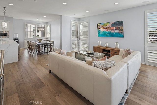 living room featuring an inviting chandelier and light hardwood / wood-style floors