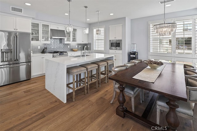 kitchen featuring sink, pendant lighting, an island with sink, and appliances with stainless steel finishes