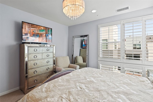 carpeted bedroom featuring a notable chandelier