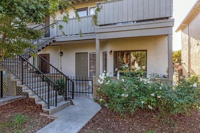 view of exterior entry with a balcony