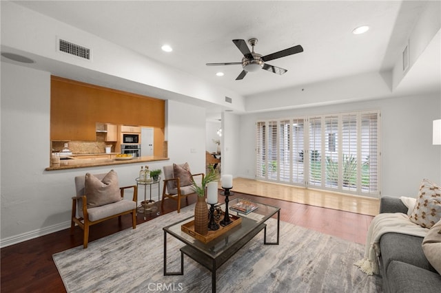 living room featuring hardwood / wood-style floors and ceiling fan