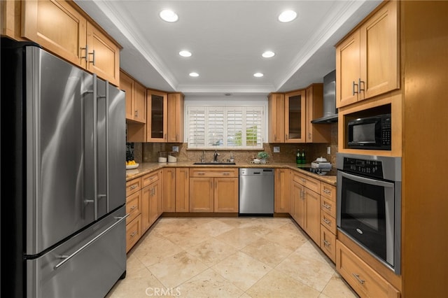 kitchen with wall chimney range hood, backsplash, black appliances, and a raised ceiling