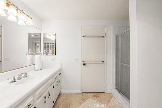 bathroom featuring a shower with door, vanity, and tile patterned flooring